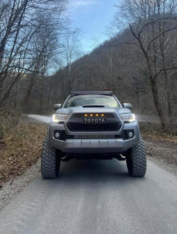 photo customer tacoma with TRD pro style grille on dirt road in the mountains