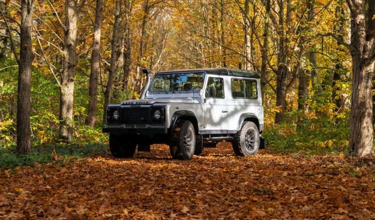 land rover offroad sitting in the woods