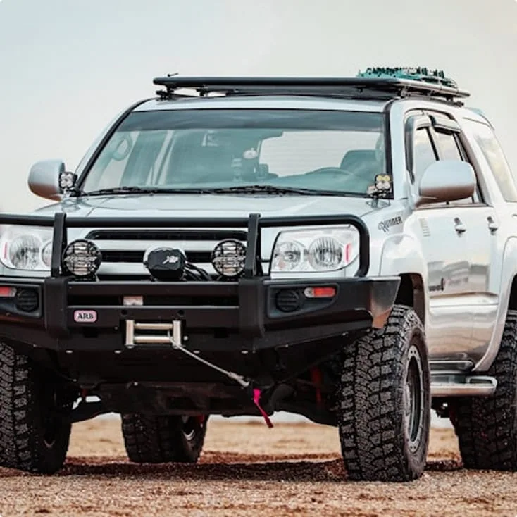 A customized off-road SUV equipped with heavy-duty bumpers, auxiliary lights, and off-road tires, perfect for adventure and rugged terrains.